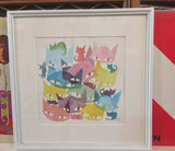 cat watercolor as described above with a large white border and white frame leaning against a shelf of records