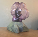 the left side of the sculpture. the cat's eye is distorted by a fold in the glass